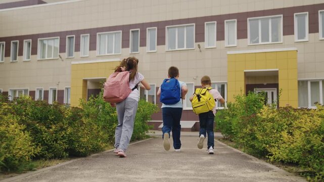 Energetic students entering building, open doors for learning, school life in motion, readiness to succeed, future dreams, community education, outdoor school experience, running into opportunity