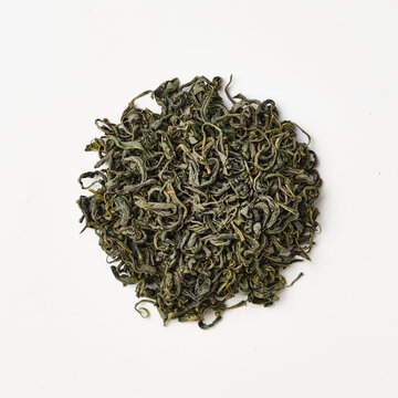 Dried green tea leaves on white background