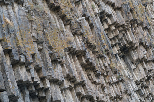 Geological formation of basalt columns in Armenia, displaying unique textures and patterns of natural stone structures in a rugged landscape