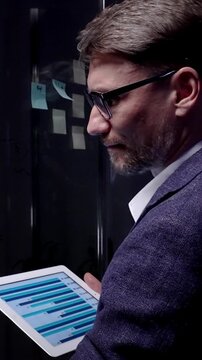Businessman analyzing data on a digital tablet, managing business strategy, developing new ideas, brainstorming solutions, and planning project execution in a modern office