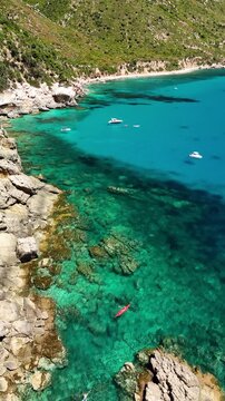 Aerial drone footage of Pedra Longa along the spectacular Baunei Coast in Sardinia, Italy, on a sunny summer day with turquoise sea and clear blue sky