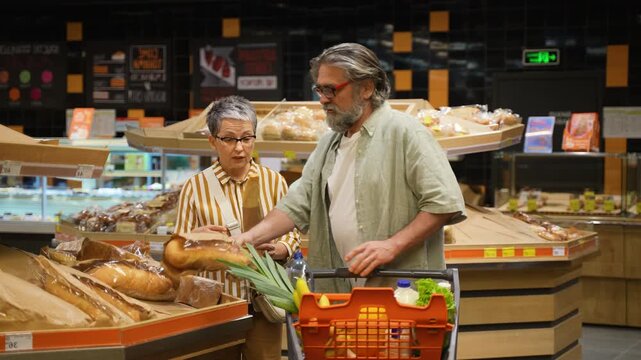 Mature couple buying fresh bread at the supermarket