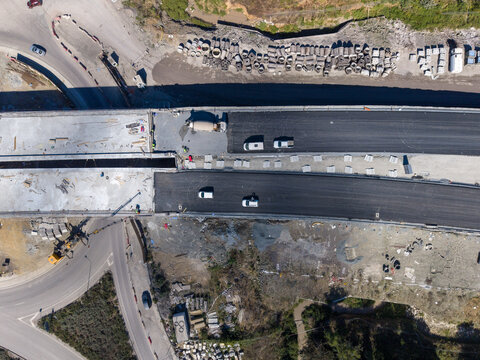 Aerial view of highway construction site with asphalt paving, heavy machinery, and vehicles in Istanbul, Istanbul, Turkiye.