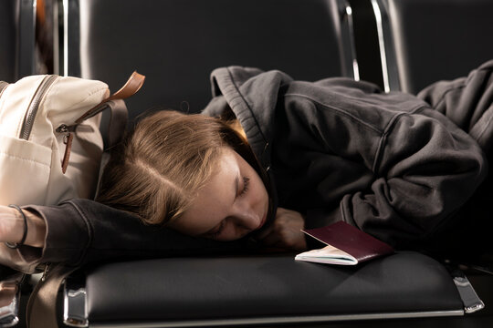 Young woman sleeping on airport bench during layover