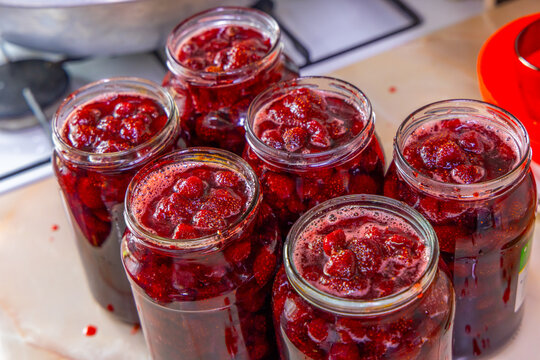 Vibrant Strawberry Jam in Glass Jars on Countertop
