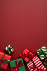 Naklejka premium Merry Christmas red background with wrapped gifts and ribbons for Happy New Year celebration on vertical maroon space