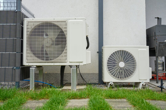 Two outdoor HVAC units installed beside house wall. Concept of home heating and cooling