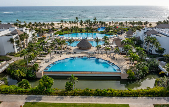 Aerial view of Hard Rock Hotel Casino Punta Cana featuring multiple swimming pools, palm trees, and white sand beach along the Caribbean Sea. Punta Cana, La Altagracia, Dominican Republic.