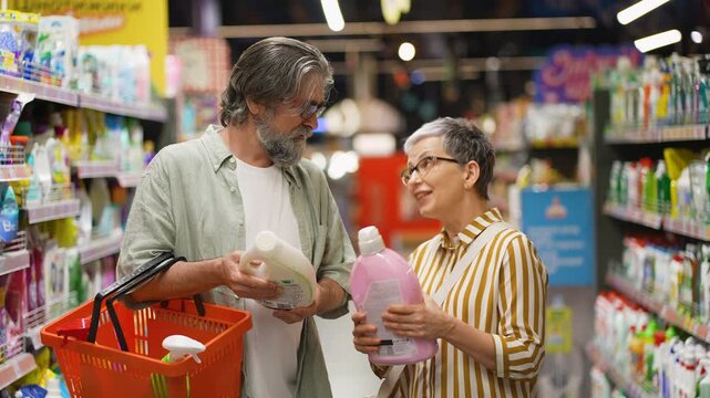 Senior couple choosing laundry detergent at supermarket