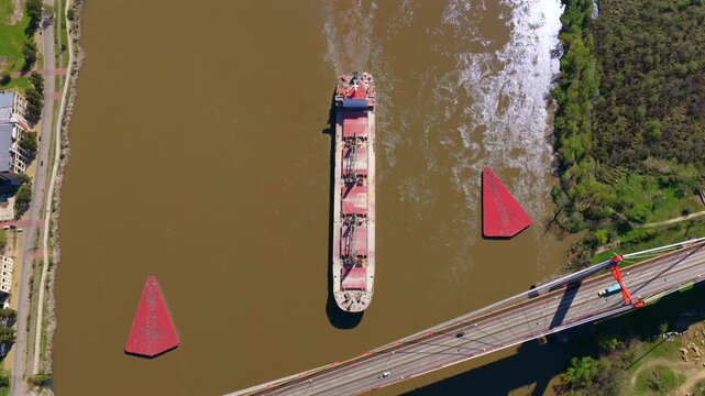 Aerial view of cargo ship sailing on the Paran&aacute; River beneath Z&aacute;rate Brazo Largo Bridge, Argentina