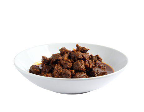 Beef rendang served in a white ceramic bowl showing spicy slow cooked meat pieces with traditional aromatic gravy for culinary menus&nbsp;