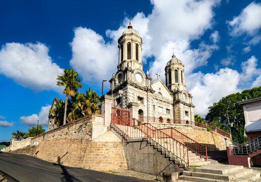 Facade of Saint John's Cathedral against a bright sky with white clouds in Saint John's, Antigua and Barbuda.