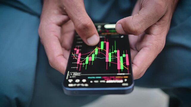 Digital financial trading application showing interactive stock market candlestick charts on a mobile phone