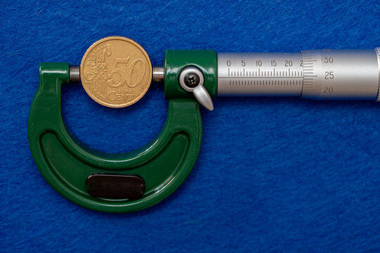Measurement of the diameter of euro coins using a high-precision instrument, a micrometer.