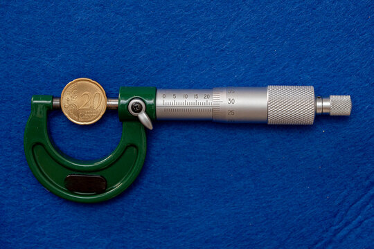 Measurement of the diameter of euro coins using a high-precision instrument, a micrometer.