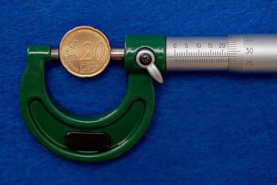 Measurement of the diameter of euro coins using a high-precision instrument, a micrometer.