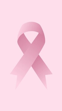 Pink ribbon gently forming and moving against soft pink vertical background, symbolizing global breast cancer awareness, support, and hope for women's health and solidarity