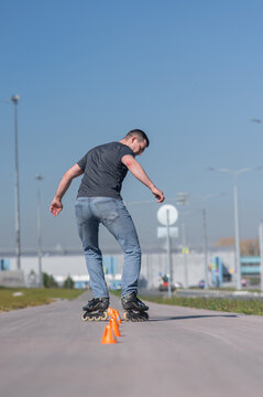 A Caucasian man rollerblades around the slalom course.