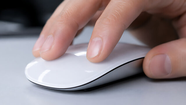 Hand using white wireless computer mouse on clean office desk close up