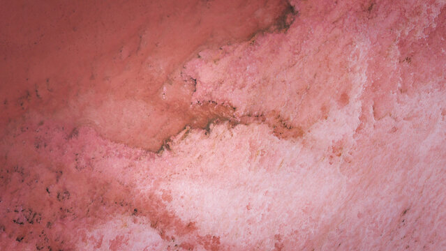 Aerial view of the vibrant pink waters and salt crust textures of Hutt Lagoon in Yallabatharra, Western Australia, Australia.