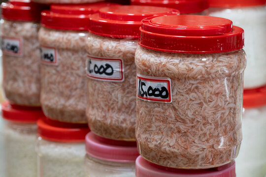 Traditional fermented salted tiny shrimps in clear plastic jars are displayed for sale at a traditional five day market in South Korea.