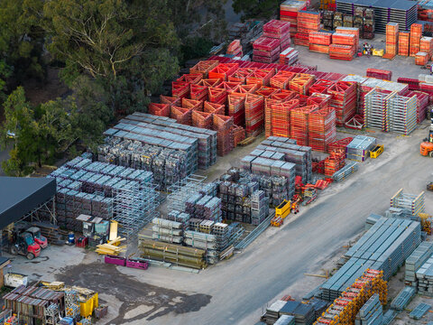 Aerial view of stacks of construction formwork, scaffolding and modular steel frames arranged in an industrial storage yard in Sydney, New South Wales, Australia.