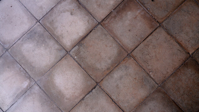 Vintage brown and gray concrete floor tiles texture backdrop close up