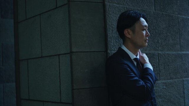 Japanese businessman with a hand on his chin thinking in the shade