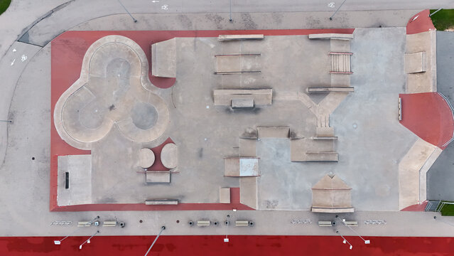 Aerial view of a concrete skatepark with ramps, bowls, and rails in Riga, Latvia.