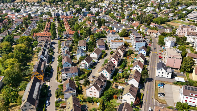 Aerial view of the residential neighborhood featuring houses with red-tiled roofs, green trees, and streets in Schaffhausen, Schaffhausen, Switzerland.