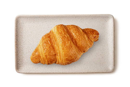 Top view of  golden croissant served on rectangular speckled cream ceramic tray. Minimalist food styling for bakery and breakfast concepts, isolated on a white background.