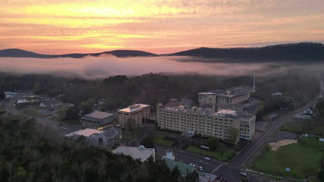 Aerial view of town buildings at sunrise with fog.