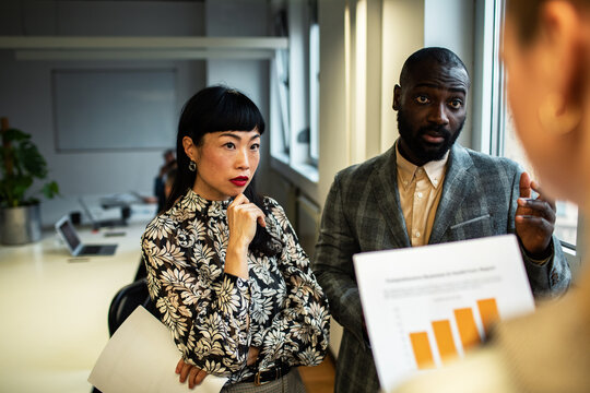 Diverse coworkers discussing sales report in office