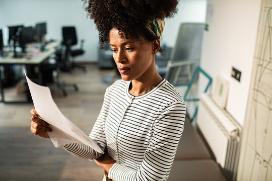 Focused woman reviewing paperwork in modern office