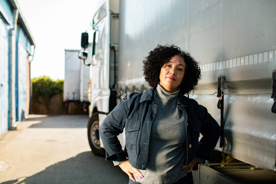 Confident female truck driver at warehouse loading bay