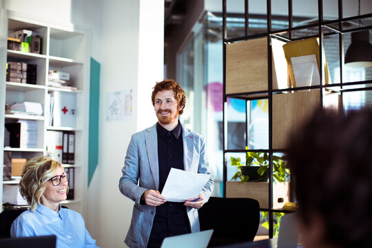 Team meeting with smiling presenter in modern office