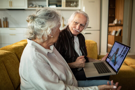 Senior couple having telemedicine video call with doctor at home