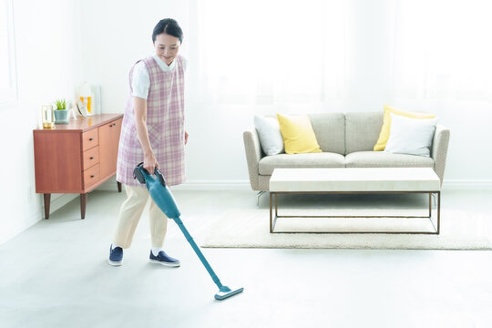 掃除機をかける家事代行の女性