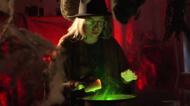 realistic witch brewing a potion. She holds a lit candle over the cauldron, drips wax into it, and chants a spell. Everyday life intertwined with traditional witchcraft. Magic and mystical atmosphere.