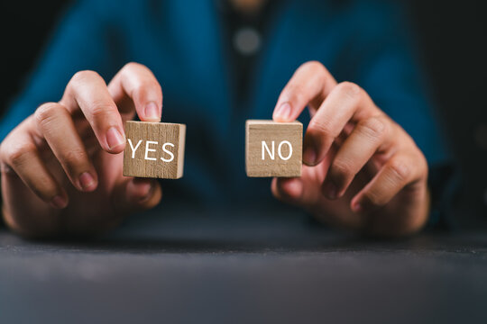 Think With Yes Or No Choice, Business Choices For Difficult Situations, Yes or no and question mark, man holding two wooden with yes or no word on it, making decision.