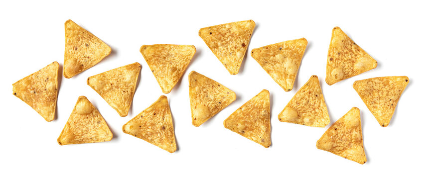 Corn tortilla chips scattered on white background in horizontal top view composition.