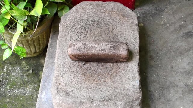 Traditional stone sil and lodi used in an Indian village kitchen for manually grinding spices and masala