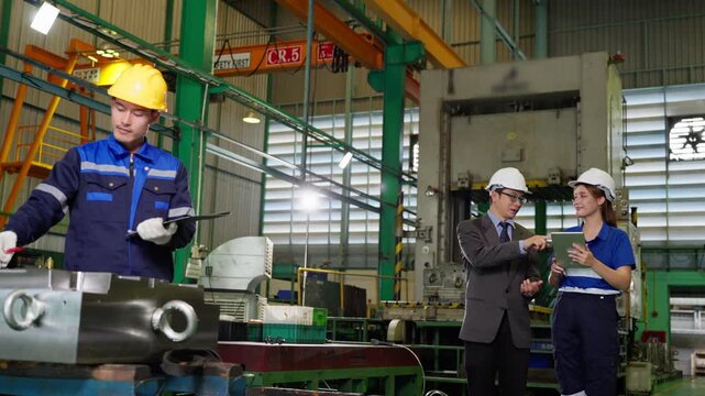 Industrial engineer and factory manager discussing project blueprint and technical specifications at manufacturing site