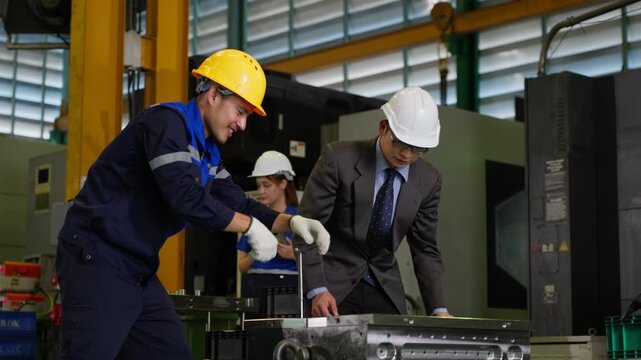 Industrial engineer inspecting machinery with manager discussing technical production details inside factory