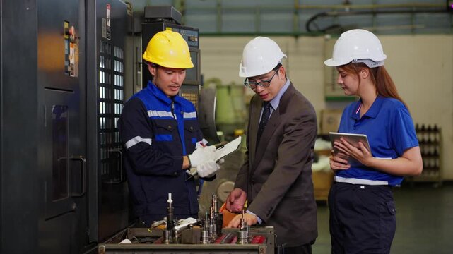 Industrial engineer team discussing production quality with digital tablet at manufacturing factory floor