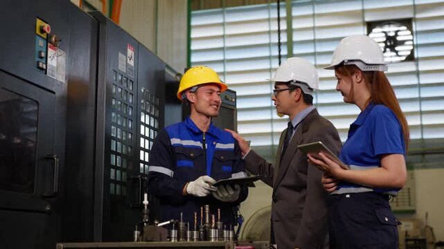 Industrial manager and supervisor discussing manufacturing production report on digital tablet inside factory facility