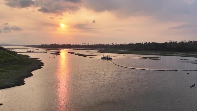 The warm sunlight creates a brilliant reflection on the water surface under a cloudy sky