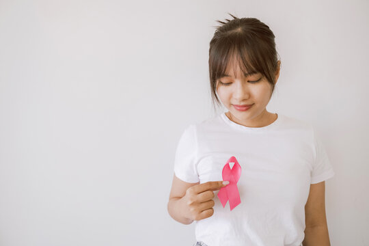 Asian woman holding pink ribbon, october pink, breast cancer awareness concept