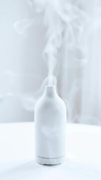 Modern white ceramic diffuser humidifier appliance with soft vapor for calm work lifestyle, creating clean minimalist interior atmosphere for wellness, relaxation, focus, healthy air care