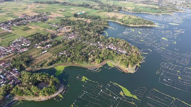 Birds eye view of Karangkates reservoir showing fish cages, shoreline villages and patchwork agricultural fields